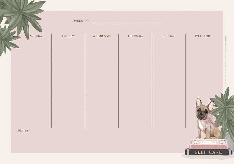 A pink weekly desk calendar with a charming French Bulldog illustration, tropical leaves, and designated space for notes. The dog, wearing a pink bow, sits on a stack of books titled "Dare to Dream", "Fashion & Style", and "Self Care".