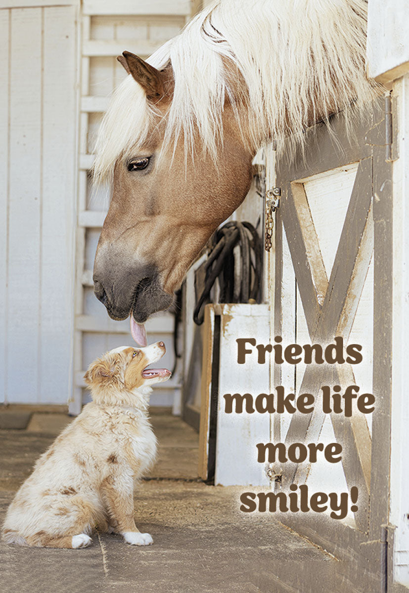 Adorable palomino horse gently licks a happy Australian Shepherd puppy on the head, with the heartwarming text 'Friends make life more smiley!' on a farm setting. A perfect cute magnet for animal lovers.