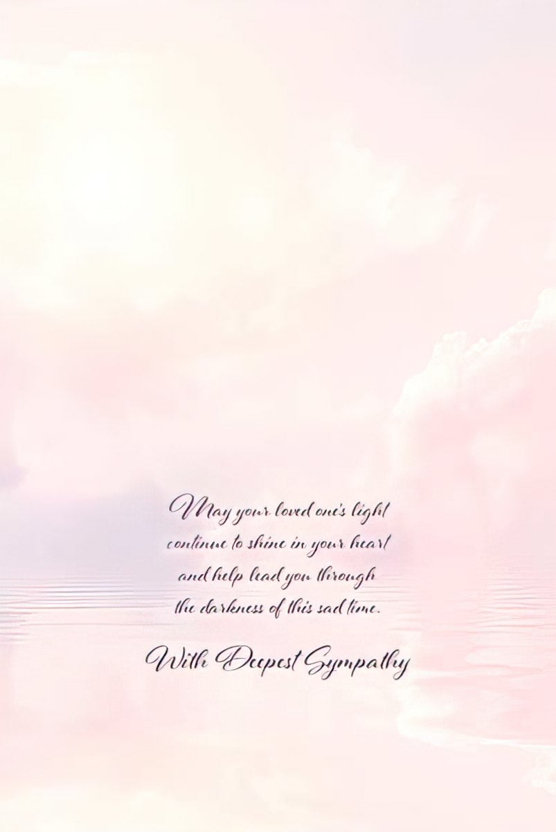 Inside of a spiritual condolence card featuring soft pink and purple cloud reflections over water, with a comforting message in elegant script: 'May your loved one's light continue to shine in your heart and help lead you through the darkness of this sad time. With Deepest Sympathy.'