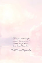 Inside of a spiritual condolence card featuring soft pink and purple cloud reflections over water, with a comforting message in elegant script: 'May your loved one's light continue to shine in your heart and help lead you through the darkness of this sad time. With Deepest Sympathy.'