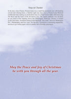 Inside of a holiday greeting card with a light blue background subtly patterned with delicate snowflakes. Centered on the card is the heartfelt message in a classic red script: 'May the Peace and Joy of Christmas be with you through all the year.'