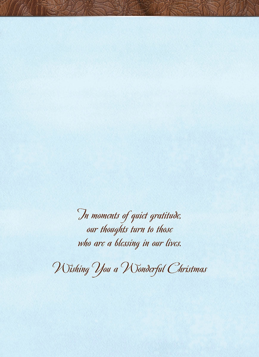 Inside view of a greeting card with elegant script text: 'In moments of quiet gratitude, our thoughts turn to those who are a blessing in our lives. Wishing You a Wonderful Christmas.' on a soft blue background.