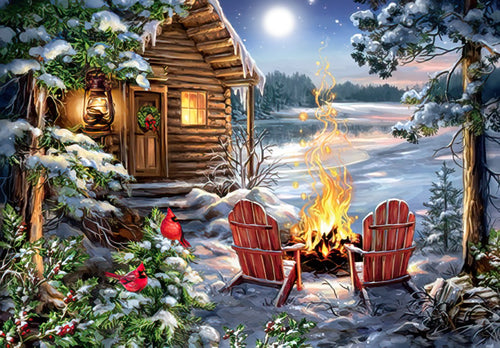 Winter wonderland greeting card featuring a rustic log cabin, crackling campfire, red Adirondack chairs, moonlit frozen lake, and vibrant red cardinals on snowy pines.