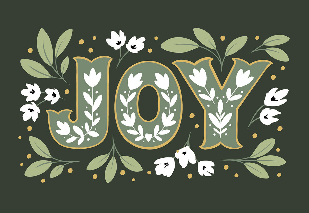 Front of a deep forest green holiday greeting card featuring large, decorative gold-outlined letters spelling "JOY" adorned with white flowers and green leaves, surrounded by small floral accents.