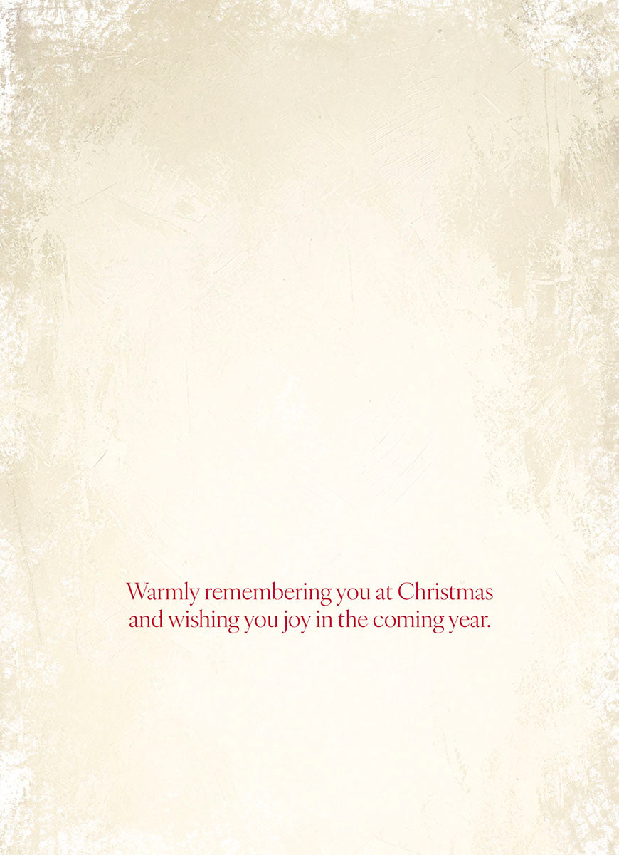 Interior of a warm-toned greeting card with a simple, heartfelt message 'Warmly remembering you at Christmas and wishing you joy in the coming year.' against a textured cream background. Perfect for sending holiday cheer.