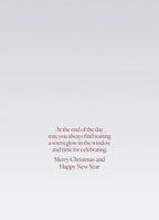 SEO optimized alt description: The interior of a heartfelt greeting card displaying a message in elegant red script against a lightly speckled grey background. The text reads: 'At the end of the day may you always find waiting a warm glow in the window and time for celebrating. Merry Christmas and Happy New Year'.