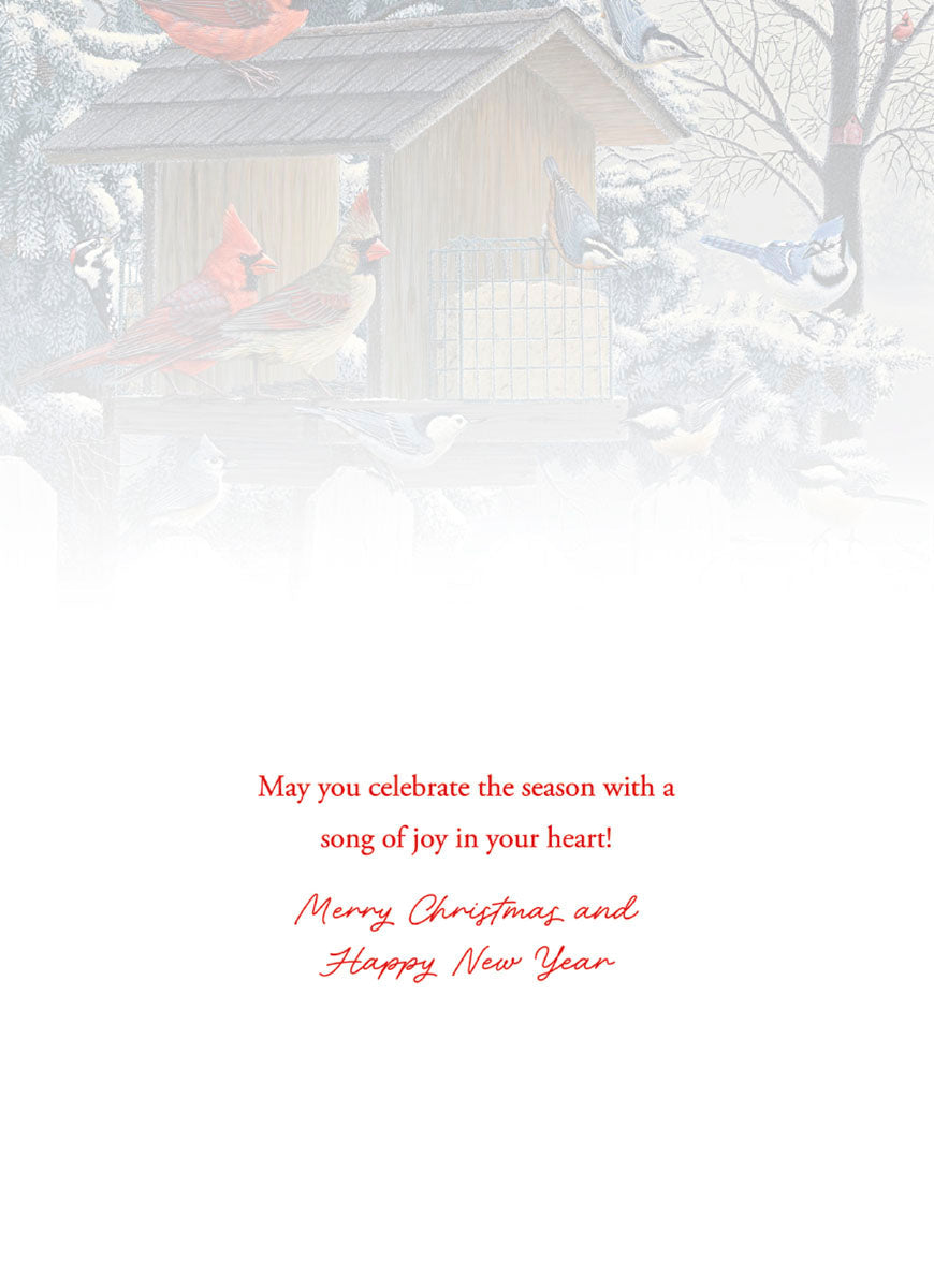 Heartfelt greeting card featuring a serene winter scene with a wooden bird feeder, vibrant red cardinals, a blue jay, nuthatches, and chickadees nestled among snow-dusted evergreen branches, conveying warm holiday wishes.