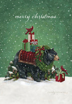 Front of a festive greeting card featuring a majestic black bear adorned with a green wreath and red tartan saddle blanket, carrying a stack of beautifully wrapped holiday presents. A bright red cardinal perches on the gifts, with falling snow against a vibrant green background, conveying a warm winter wonderland scene. The words 'merry christmas' are subtly displayed at the top.