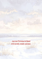 Inside of a greeting card with a serene watercolor snowy landscape background. Red text reads '...may your Christmas be blessed with warmth, wonder, and peace.', conveying heartfelt seasonal greetings.