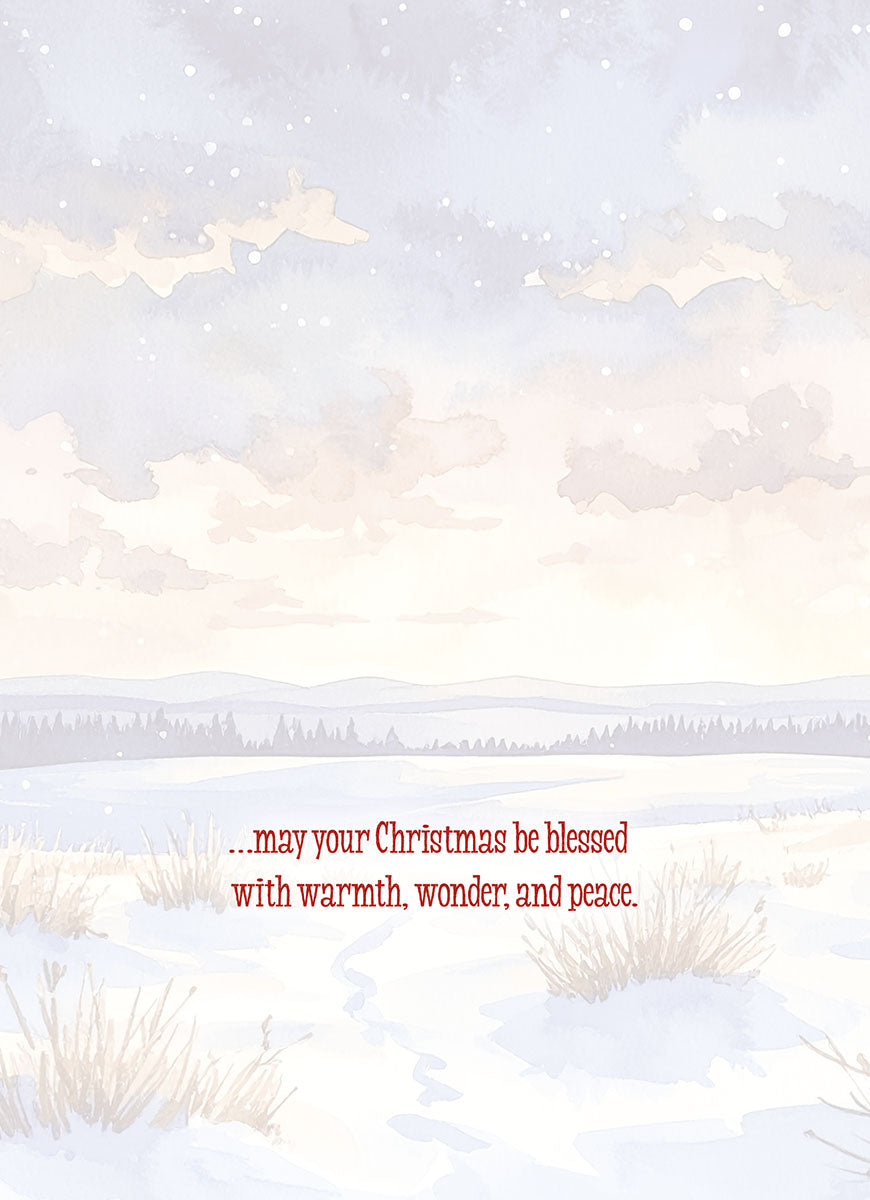 Inside of a greeting card with a serene watercolor snowy landscape background. Red text reads '...may your Christmas be blessed with warmth, wonder, and peace.', conveying heartfelt seasonal greetings.
