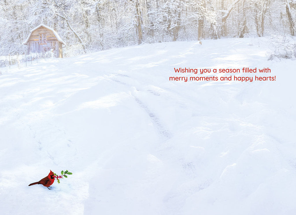 Inside of a serene winter greeting card showcasing a snowy field and a red cardinal. Text wishes 'Wishing you a season filled with merry moments and happy hearts!'.