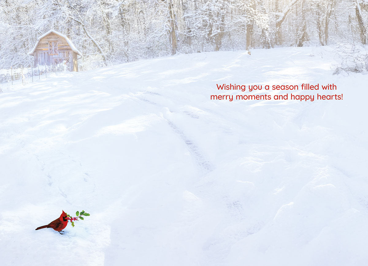 Inside of a serene winter greeting card showcasing a snowy field and a red cardinal. Text wishes 'Wishing you a season filled with merry moments and happy hearts!'.