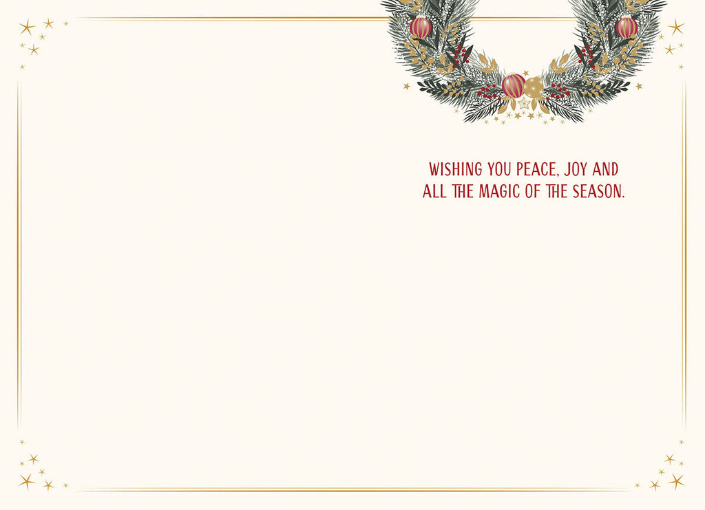 Inside of a holiday greeting card, showing a blank space for a personal message and the pre-printed text 'WISHING YOU PEACE, JOY AND ALL THE MAGIC OF THE SEASON' in red, with a gold border and a partial festive wreath design.