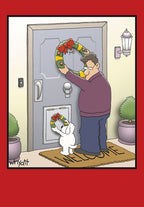 Humorous cartoon Christmas card depicting a man hanging a large holiday wreath on a front door, while his small white dog adds a tiny matching wreath to its doggy door below. A 'WELCOME' mat is visible.
