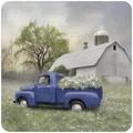 A vintage blue pickup truck filled with white flowers, parked in a lush green field of wildflowers. In the background, a rustic gray barn and silo stand under a soft, cloudy sky, with a weeping willow tree to the left. The scene evokes a peaceful, serene farmhouse aesthetic.