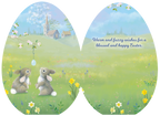 Open Easter greeting card revealing the sweet message 'Warm and fuzzy wishes for a blessed and happy Easter.' alongside the charming illustration of two bunnies in a spring meadow with a church and hanging egg design.
