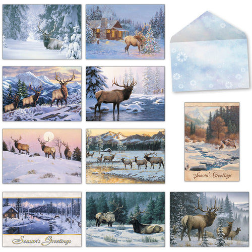 Assortment of nine serene winter landscape greeting cards featuring majestic elk, snow-covered forests, and a cozy cabin, with a snowflake-patterned envelope.