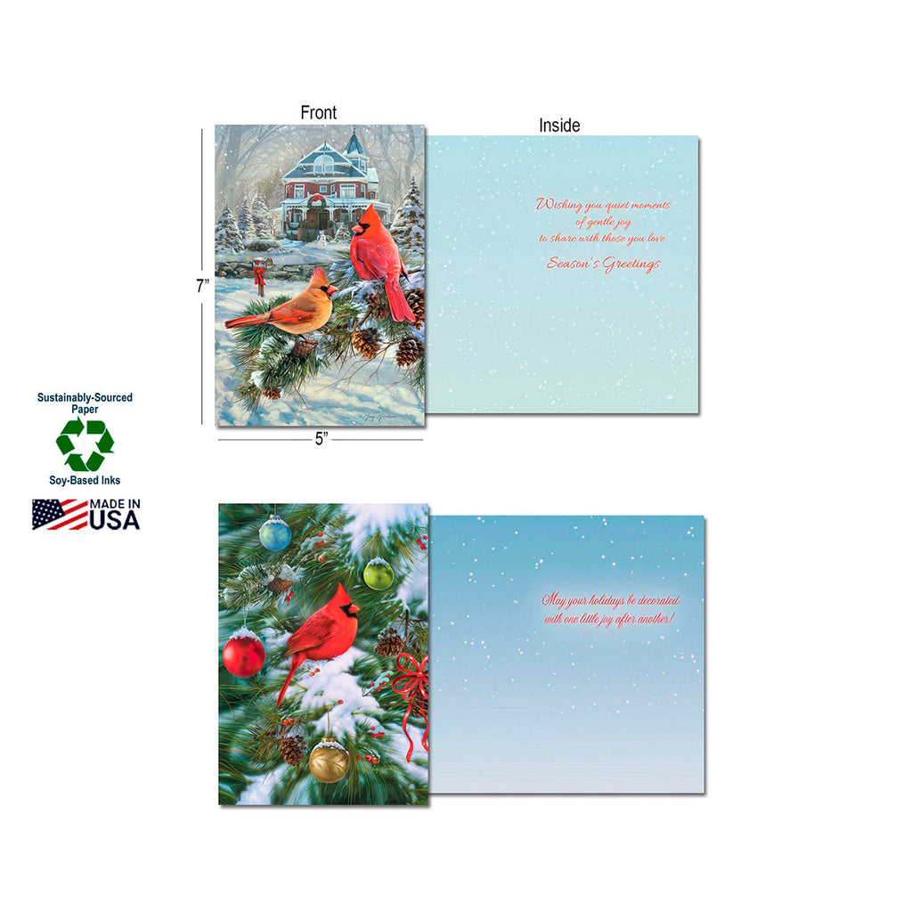 Two open greeting cards demonstrating front and inside designs. One card features a snowy house with cardinals on a pine branch, with an inside message 'Wishing you quiet moments... Season's Greetings'. The second card shows a cardinal on a decorated Christmas tree, with an inside message 'May your holidays be decorated with one little joy after another!'. Labels indicate 'Sustainably-Sourced Paper', 'Soy-Based Inks', and 'Made In USA', and card dimensions 5"x7".