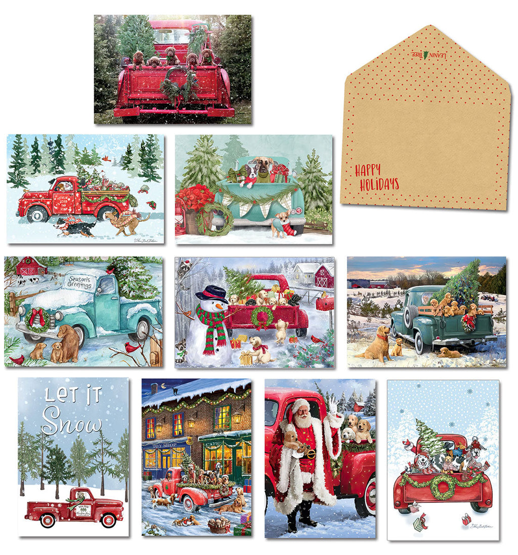 Assortment of festive holiday greeting cards featuring vintage red and teal trucks laden with adorable puppies, gifts, and evergreen trees in snowy winter scenes, with a blank kraft envelope.