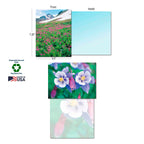 Detailed view of a single Colorado greeting card featuring a pink wildflower field, showing its blank light blue interior, with an inset of purple Colorado Columbine flowers. Labels highlight 'Sustainably-Sourced Paper' and 'Made in USA'.