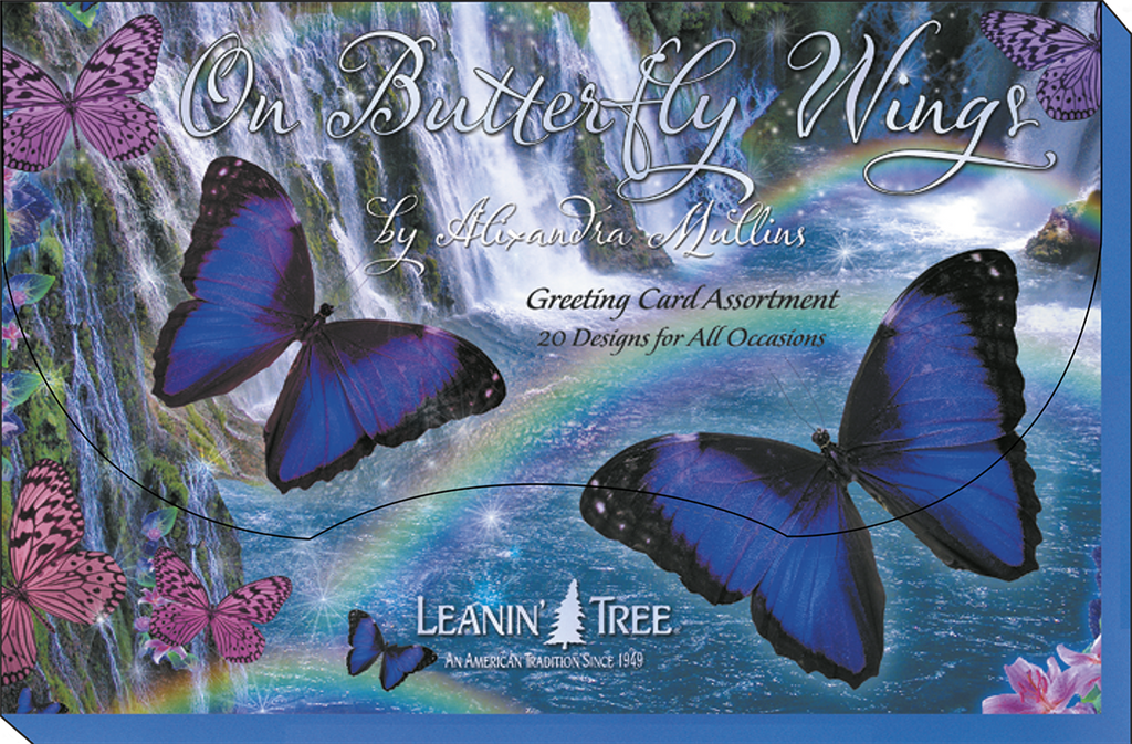 Close-up of 'On Butterfly Wings' greeting card assortment packaging, featuring two large blue morpho butterflies against a shimmering waterfall and rainbow, with Leanin' Tree branding.