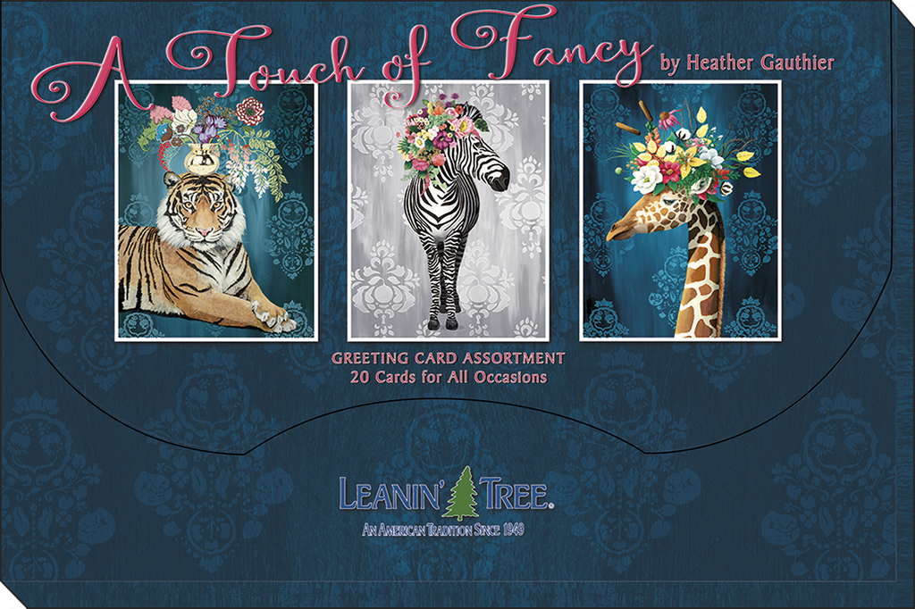Dark blue packaging box for 'A Touch of Fancy by Heather Gauthier' greeting card assortment, featuring three framed animal art cards: a tiger, a zebra, and a giraffe, all adorned with flowers, with the 'Leanin' Tree' logo at the bottom.