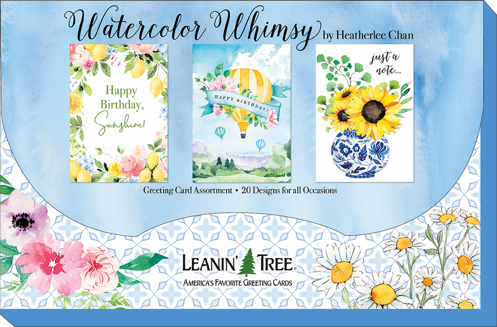 Leanin' Tree 'Watercolor Whimsy' collection display board showcasing three popular designs: 'Happy Birthday Sunshine' with lemons, a hot air balloon 'Happy Birthday', and 'Just a Note' with sunflowers in a blue vase. Twenty designs for all occasions.