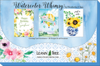 Leanin' Tree 'Watercolor Whimsy' collection display board showcasing three popular designs: 'Happy Birthday Sunshine' with lemons, a hot air balloon 'Happy Birthday', and 'Just a Note' with sunflowers in a blue vase. Twenty designs for all occasions.