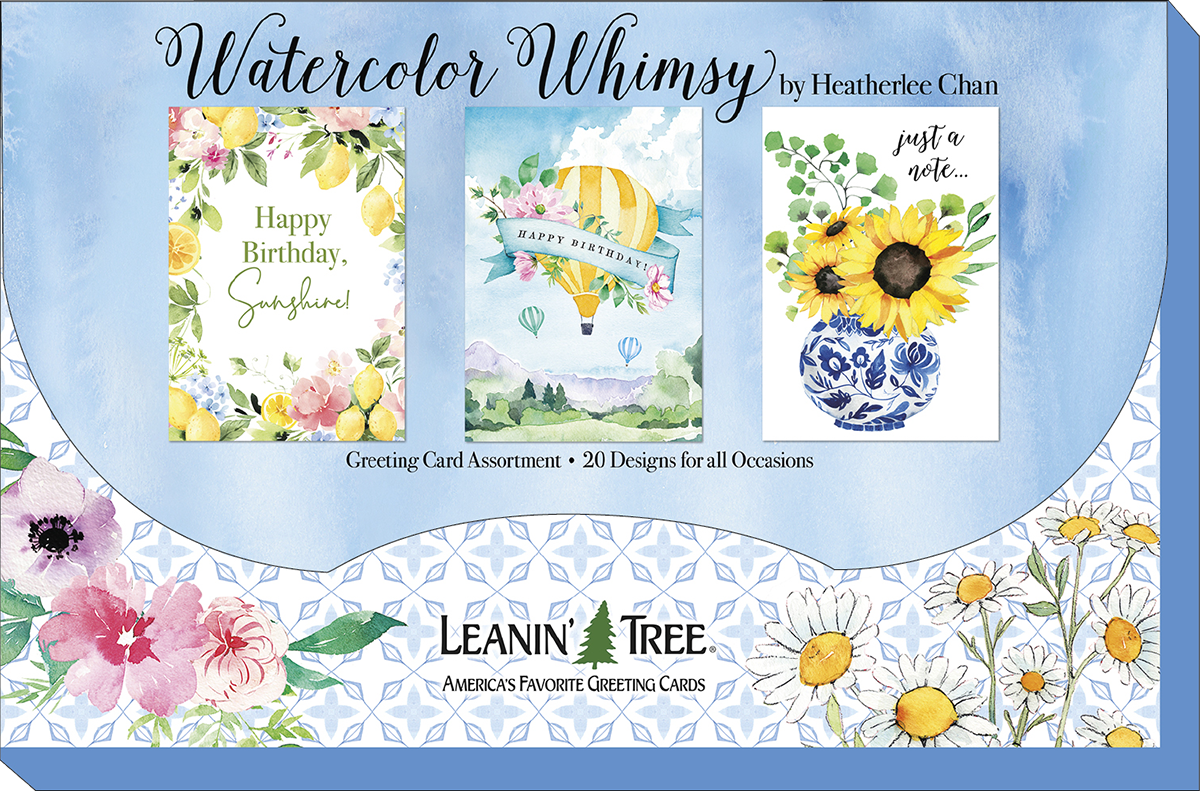 Leanin' Tree 'Watercolor Whimsy' collection display board showcasing three popular designs: 'Happy Birthday Sunshine' with lemons, a hot air balloon 'Happy Birthday', and 'Just a Note' with sunflowers in a blue vase. Twenty designs for all occasions.