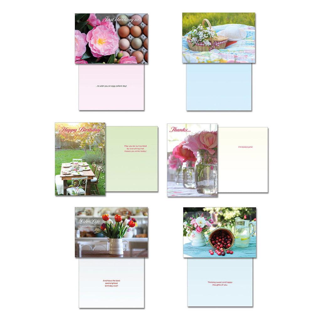 Selection of Leanin' Tree greeting cards featuring front and inside messages: 'Just checking in' with eggs, 'Happy Birthday' with a garden setting, 'Live Life' with tulips, 'Thinking of You' with a basket of flowers, 'Thanks...' with roses in jars, and 'Happy Birthday' with garden scenery, illustrating various thoughtful sentiments.