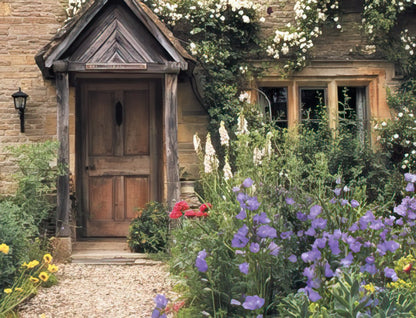Idyllic wooden door of a quaint stone cottage with a welcoming porch, surrounded by a vibrant, overgrown garden.
