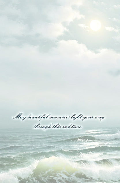 The inside of a sympathy card with a serene ocean and sky background, bearing the message: 'May beautiful memories light your way through this sad time.'
