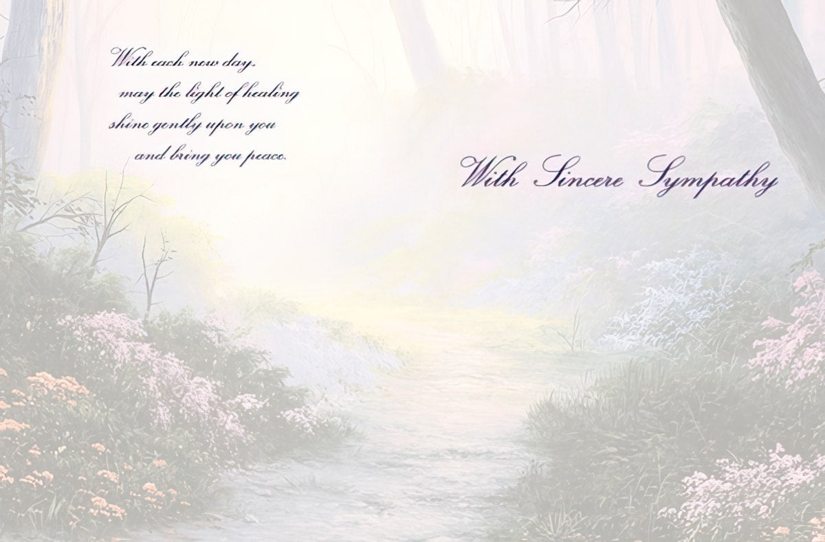 The inside of a sympathy card with a misty forest path background and 'With each new day, may the light of healing shine gently upon you'.