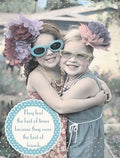 Charming birthday greeting card featuring two smiling young girls embracing, wearing playful sunglasses and flower headbands. The design conveys heartwarming friendship, ideal for celebrating a special gal pal's day.