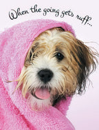 Front of an encouragement greeting card featuring a fluffy brown and white dog wrapped in a pink towel, sticking out its tongue, with black script text "When the going gets ruff...".