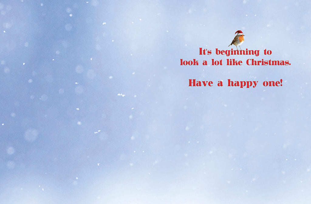 Inside of a snowy holiday greeting card featuring a small robin and heartwarming text: 'It's beginning to look a lot like Christmas. Have a happy one!'