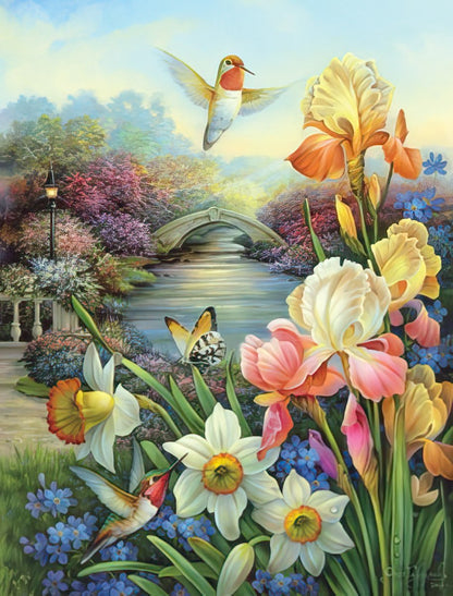 Picturesque card art with hummingbirds, colorful irises, white daffodils, and a quaint stone bridge over a flowing stream.