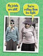 Funny birthday card featuring two elderly figures with sunglasses and speech bubbles; one says 'My joints are stiff,' the other 'You're rolling them too tight,' implying cannabis humor for a good laugh.