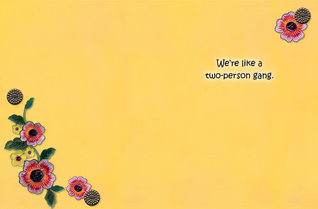 Inside of a friendship greeting card with a bright yellow background, decorated with vintage floral accents and the sweet message 'We're like a two-person gang.'