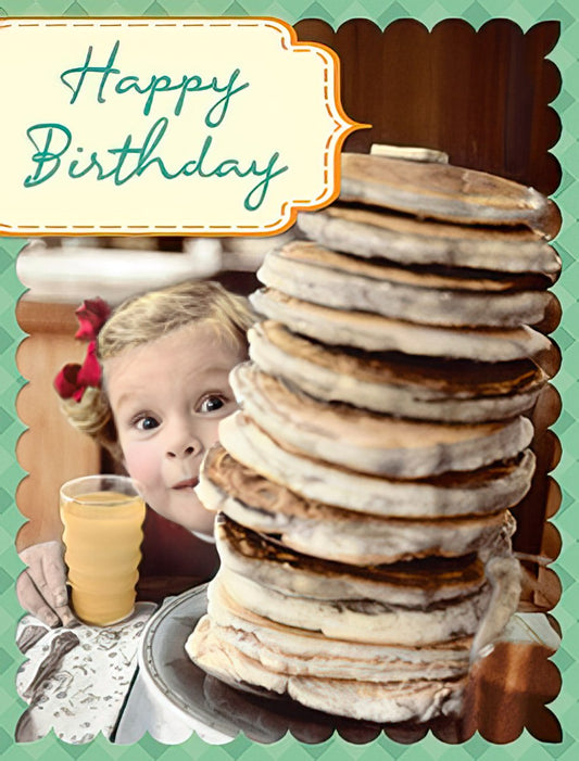 Happy Birthday card front with a cute little girl peeking over a tall stack of pancakes, holding a glass of orange juice.