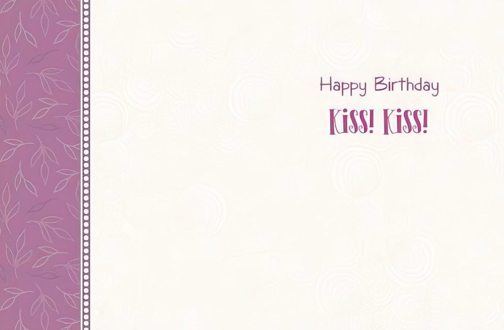 Inside of a cream-colored birthday greeting card featuring 'Happy Birthday Kiss! Kiss!' text in purple, with a decorative purple patterned border.