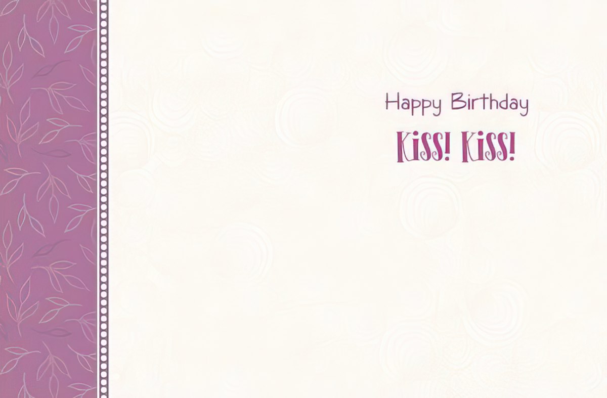 Inside of a cream-colored birthday greeting card featuring 'Happy Birthday Kiss! Kiss!' text in purple, with a decorative purple patterned border.