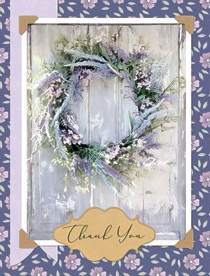 Front of a thank you greeting card featuring an elegant lavender wreath on a rustic wooden door, with 'Thank You' in gold script.