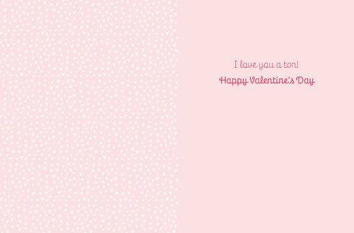 Inside of a cute greeting card with a light pink heart pattern background and the message 'I love you a ton! Happy Valentine's Day' in pink script font.