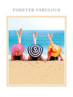 Greeting card featuring three women in colorful sun hats, upside down with legs in the air on a sandy beach, with text 'FOREVER FABULOUS'. Perfect lighthearted birthday card for a friend.
