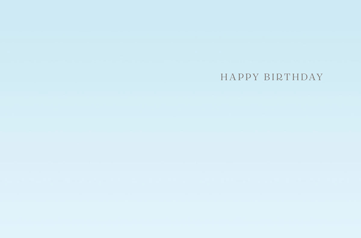 Inside of a light blue greeting card with elegant 'HAPPY BIRTHDAY' text, offering space for a personalized message.