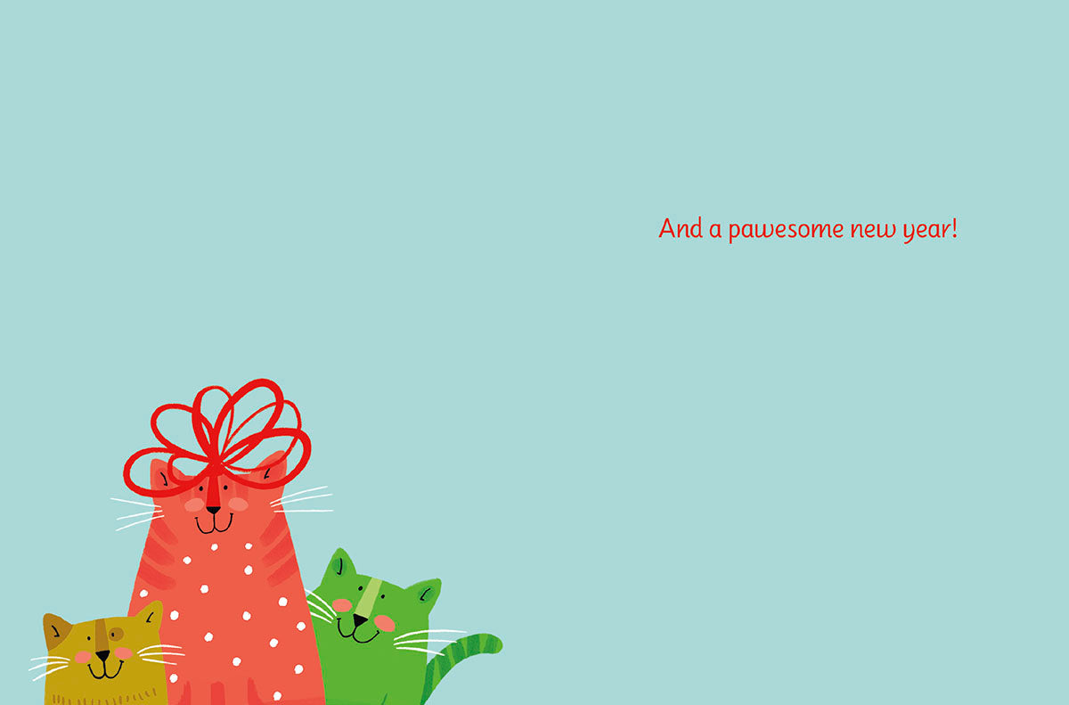 Inside of a holiday greeting card showing the top of three colorful cartoon cats (red, yellow, green) with a red bow, on a plain light blue background. Text reads 'And a pawesome new year!'.