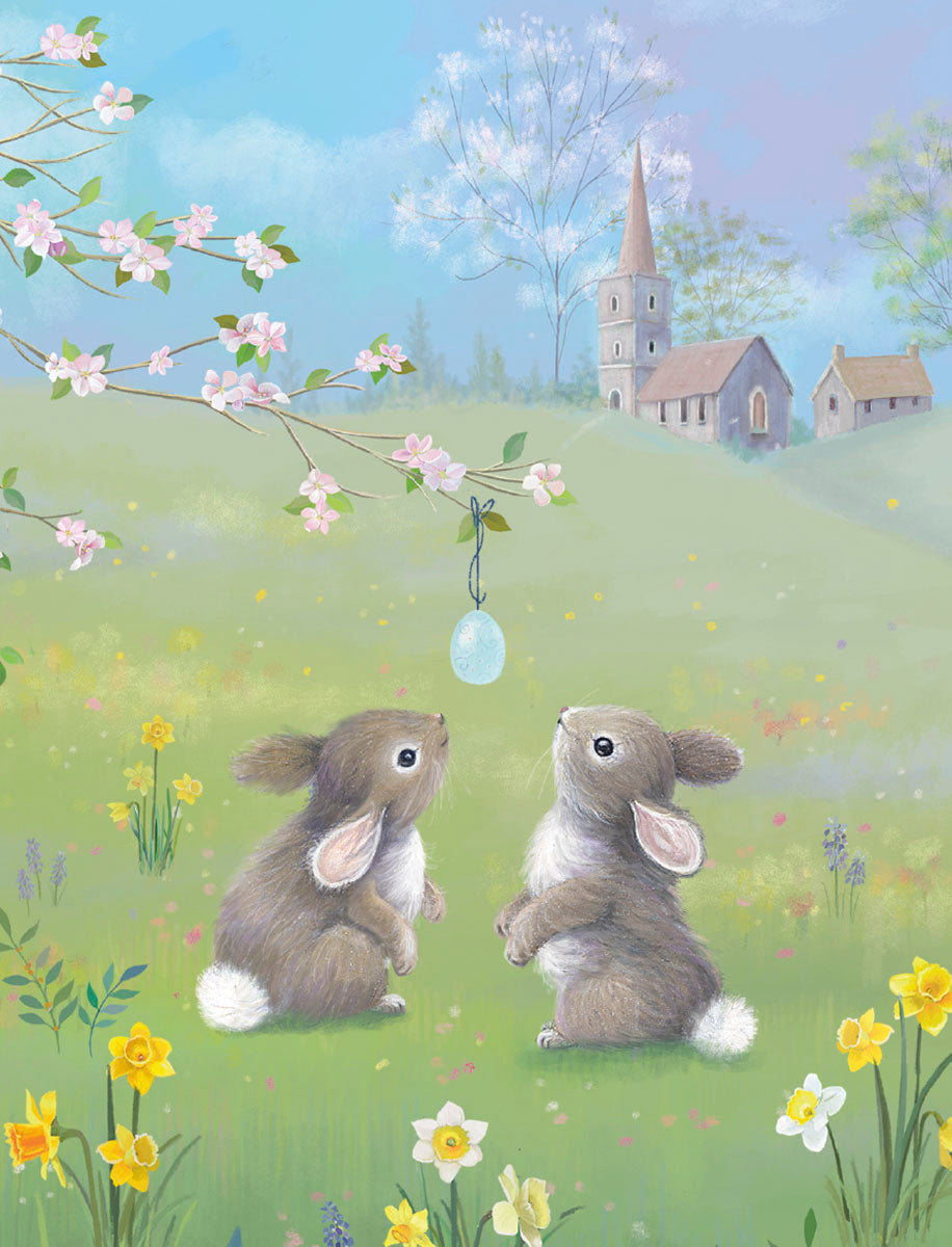 Two adorable baby bunnies gaze up at a delicate blue decorated egg hanging from a cherry blossom branch in a vibrant spring meadow with daffodils, a distant church, and a blue sky, perfect for a joyful religious holiday message.
