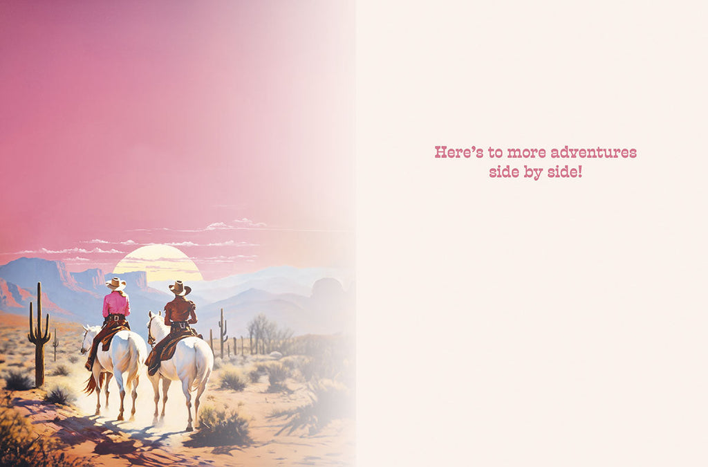 Inside of a romantic birthday card with a desert sunset landscape on the left and a blank space on the right, featuring the printed message 'Here's to more adventures side by side!'.
