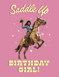 Vibrant pink greeting card featuring a joyful African American woman in a denim shirt and cowboy hat, riding a rearing brown horse with 'Saddle Up' and 'Birthday Girl!' text and white stars. Perfect for a fun celebration.